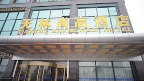 A hotel entrance with a modern design, featuring a large sign with hotel name and a revolving door. - Hangzhou Tian Lin Shang Gao Hotel (Hangzhou)
