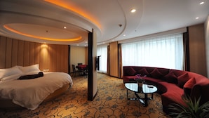 A hotel room with a bed, a red sofa, a small table, and a large window. - Hangzhou Tian Lin Shang Gao Hotel (Hangzhou)