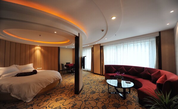 A hotel room with a bed, a red sofa, a small table, and a large window. - Hangzhou Tian Lin Shang Gao Hotel (Hangzhou)