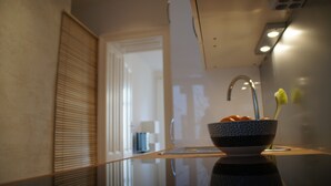 A bathroom with a glass sink, a toothbrush holder, and a towel rack.