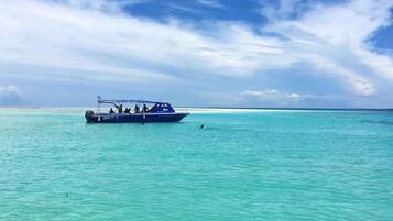 A boat on turquoise water with a clear sky.