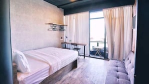 A bedroom with a bed, a desk, a chair, and a sofa. - Cube Bed Station - Hostel (Semporna)