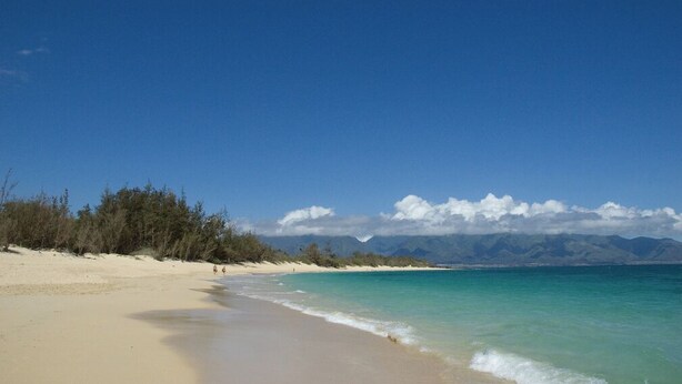 A beach with clear turquoise water, sandy shore, and distant mountains. - Great Location, Clean, Beachy 1BR Cottage (Haiku-Pauwela)