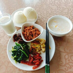 A plate with various dishes including rice balls, soup, and stir-fried vegetables. - Long Yun Farm (Zhuqi)