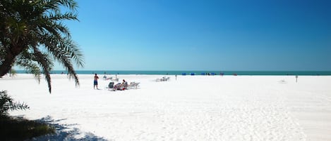 Na praia, espreguiçadeiras, toalhas de praia