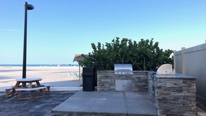 An outdoor patio with a barbecue grill, a trash can, and a picnic table. - Great rates for September! SIESTA KEY GULF 2 bed 2 bath condo Jamaica Royale 104 (Sarasota)
