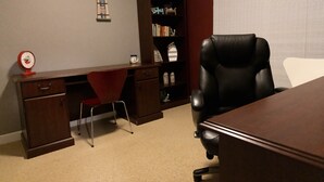 A conference room with a desk, a leather chair, a bookshelf, and a red chair. - Luxury Living On The Lake (La Porte)
