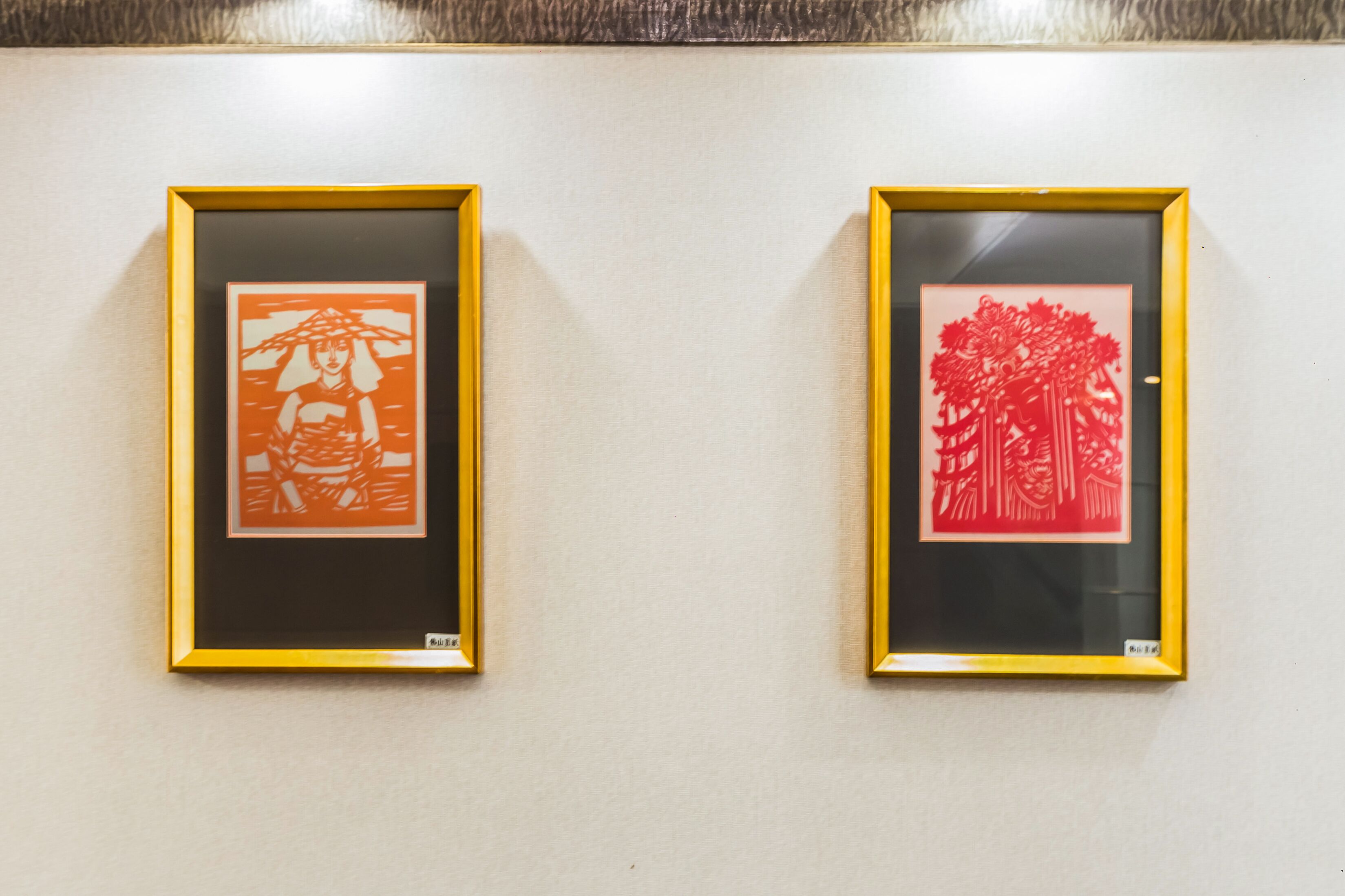 Two framed artworks on a wall.