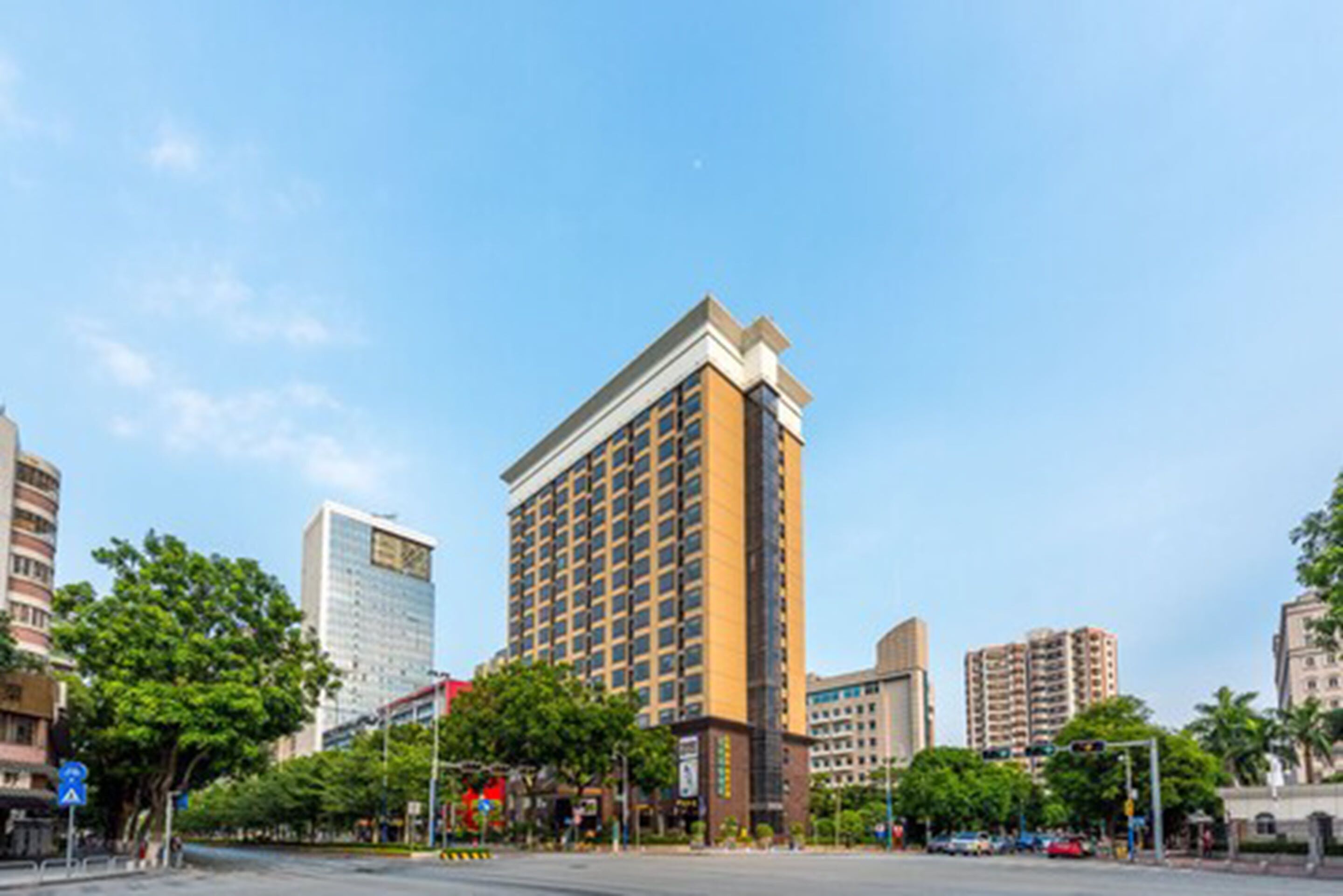 A tall hotel with a modern design, featuring a prominent corner entrance and multiple floors.