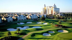 A golf course with bunkers, a clubhouse, and a hotel in the background. - Reunion South facing pool home 3 bed/3.5 baths (Reunion)