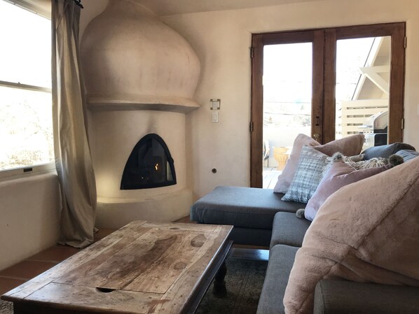 A cozy living room with a fireplace, a sofa, and a coffee table.