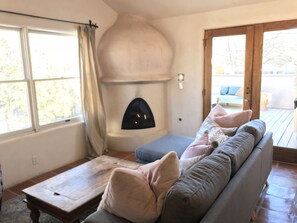 Ein gemütliches Wohnzimmer mit Kamin, einer Couch und einem Holztisch.