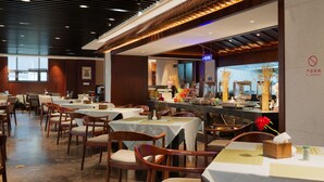 Een restaurant met tafels en stoelen, een toonbank met etenswaren en een 'Niet Roken'-bord.