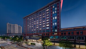 Een meerhoog hotel met een moderne gevel, grote ramen en een opvallend entreegebied.