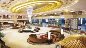 A spacious lobby with a central fountain, multiple seating areas, and a grand chandelier. - Regal Palace Hotel  (Dongguan)