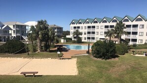 Ein Hotel mit Schwimmbad, mehreren Balkonen und einem gepflegten Rasen.