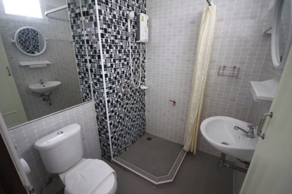 A bathroom with a shower, toilet, and sink.