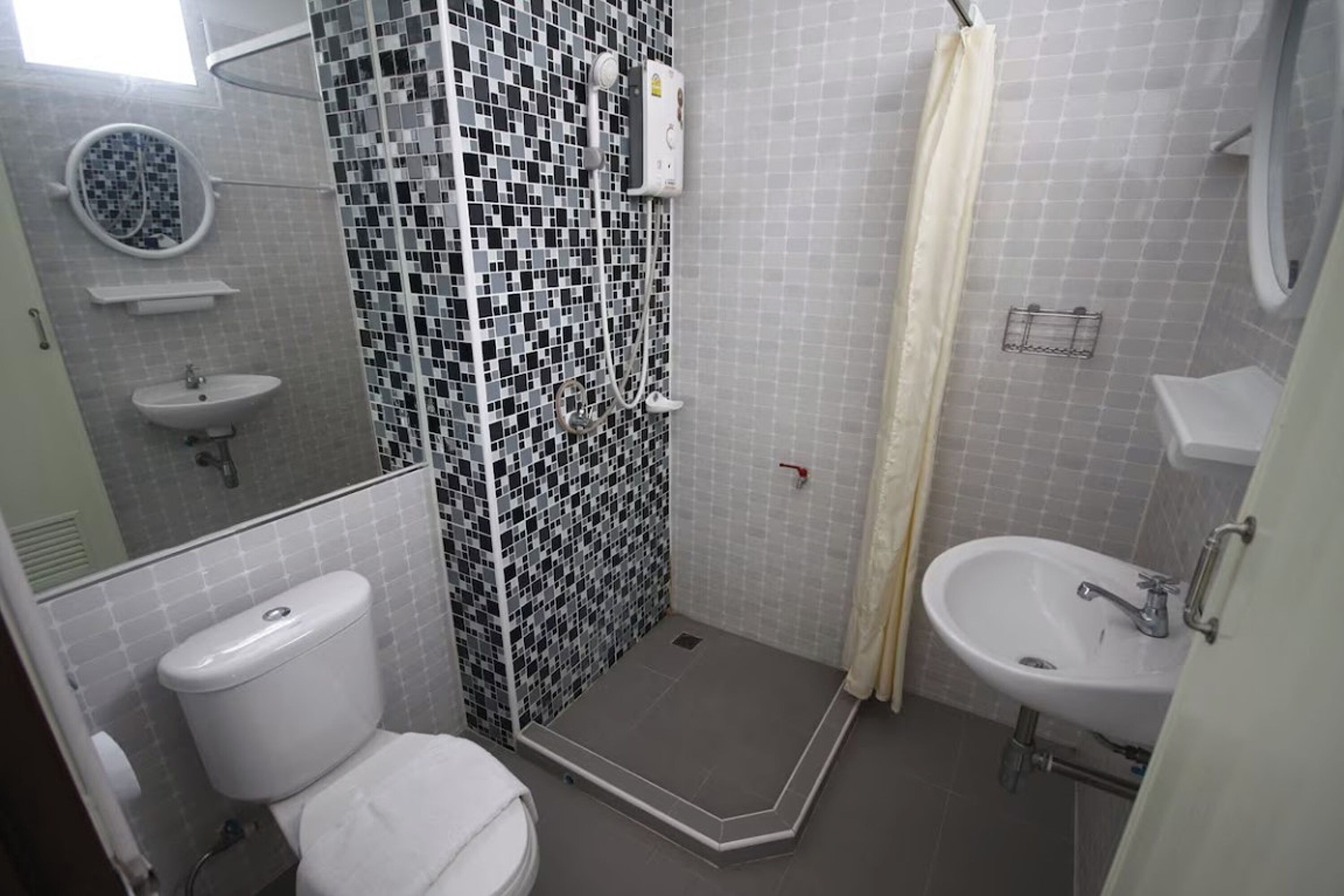 A bathroom with a shower, toilet, and sink.