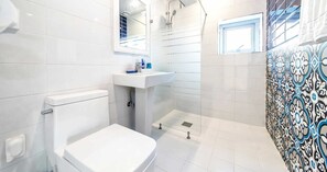 A bathroom with a toilet, sink, and shower.