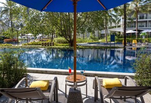 A poolside area with lounge chairs and umbrellas, surrounded by lush greenery and a clear pool. - X10 Khaolak (Takua Pa)