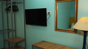 A room with a desk, a mirror, a TV, and a shelving unit. - New Era Mandaue Budget Hotel (Mandaue)