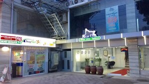 A hotel entrance with a 'New Era' sign, a money exchange, and a 24-hour service. - New Era Mandaue Budget Hotel (Mandaue)