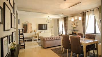 Habitación Deluxe, 2 habitaciones | Zona de estar | Una televisión LED