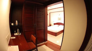 A room with a bed, a chair, a desk, and a wardrobe. - Rathna Residency (Coimbatore)