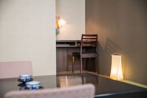 Ein Essbereich mit Tisch, Stühlen, einer Lampe und einer Wandleuchte.