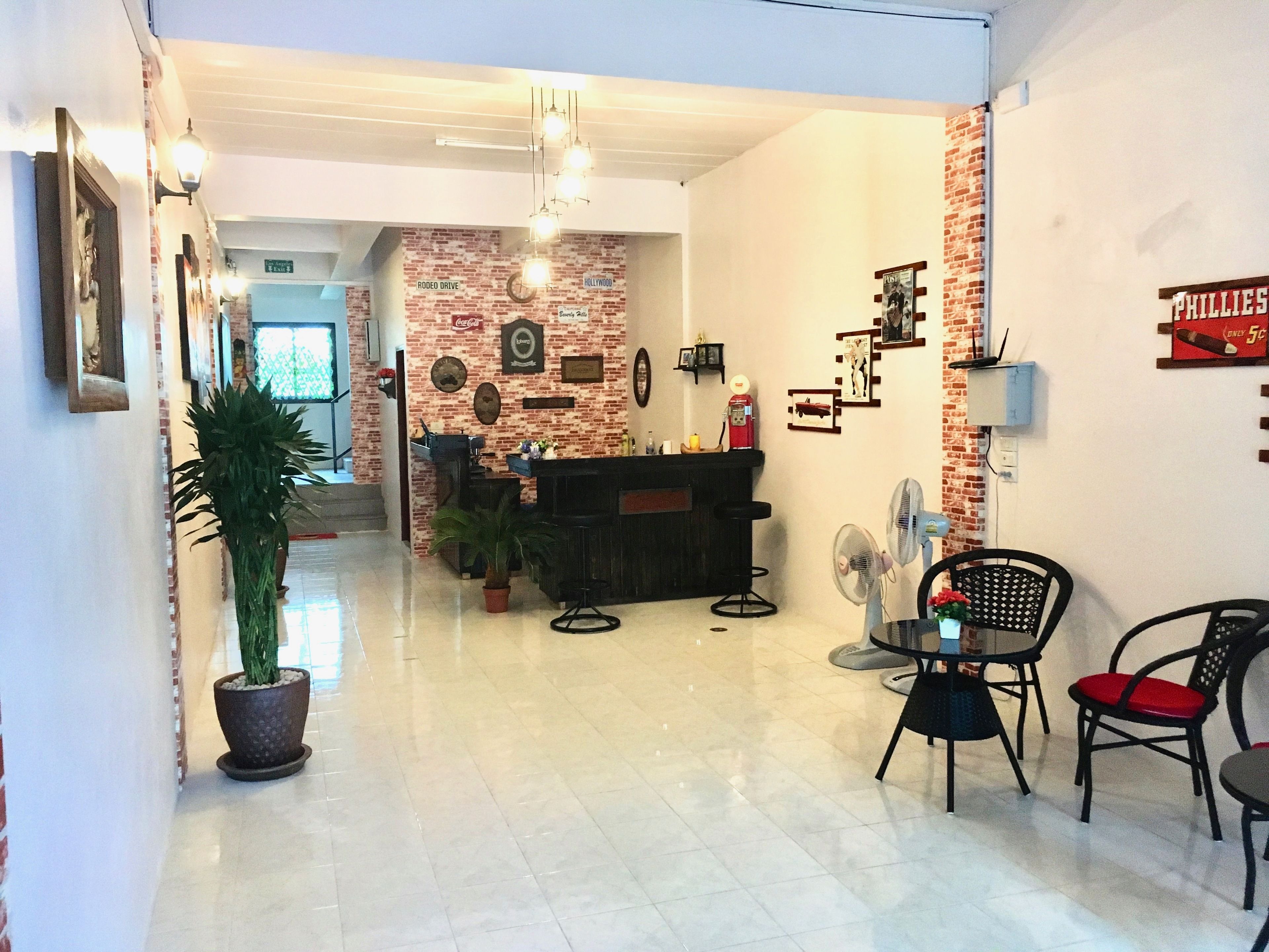 A reception area with a brick wall, a reception desk, a Coca-Cola sign, a clock, and a sign for 'PHILLIES'.