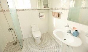 A bathroom with a toilet, sink, and shower. - Skyline Pension (Jeju City)