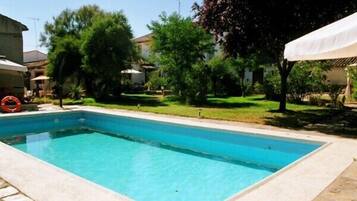 Una piscina al aire libre, sombrillas, tumbonas