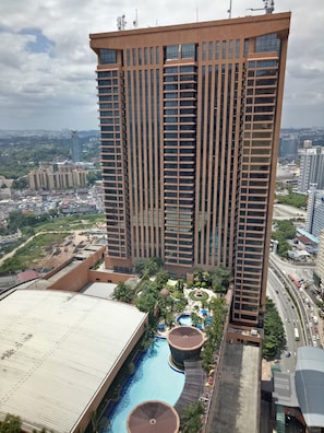 Ein Hochhaus-Hotel mit Pool auf dem Dach und gepflegten Gärten.