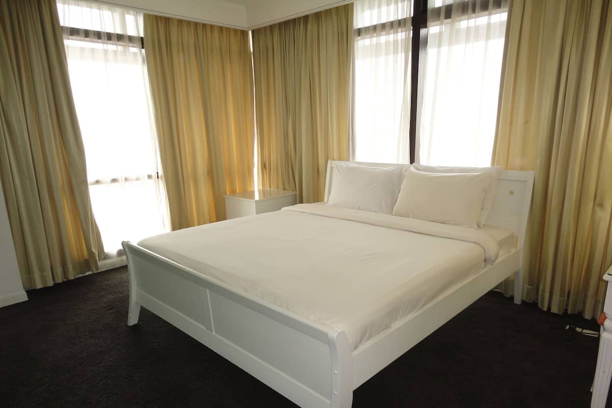 A hotel room with a single bed, a bedside table, and a nightstand.
