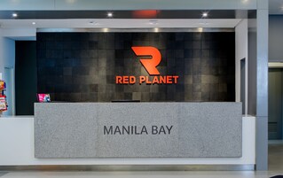 Uma receção com um letreiro a indicar "RED PLANET" e "MANILA BAY".