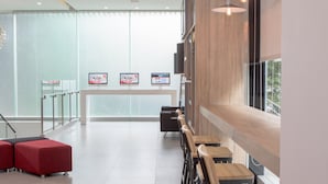 A modern interior with a long counter, seating area, and glass walls.