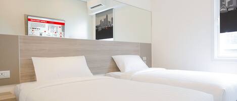Habitación de hotel con dos camas, un espejo, un cartel con un póster de paisaje urbano y un letrero de Red Planet Hotels.