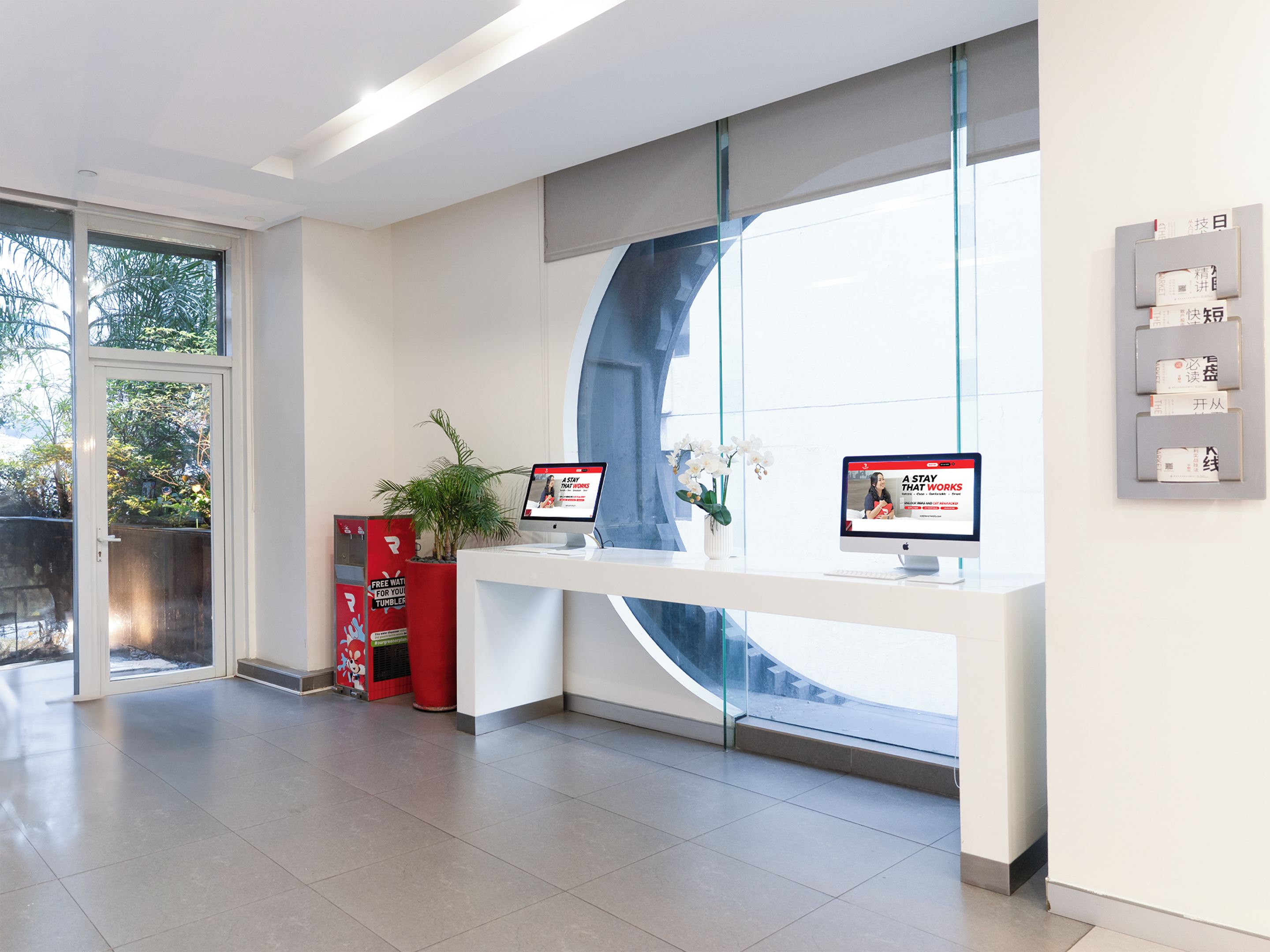 A reception area with a glass partition, a reception desk, and a computer monitor displaying a webpage.