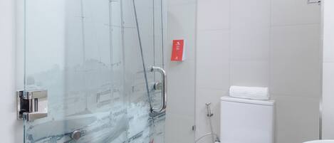 Un baño moderno con cabina de ducha de vidrio, inodoro blanco y lavabo.