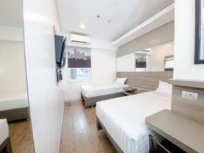 A modern hotel room with a bed, a desk, a chair, a window with a cityscape view, and an air conditioning unit. - Red Planet Manila Binondo (Manila)