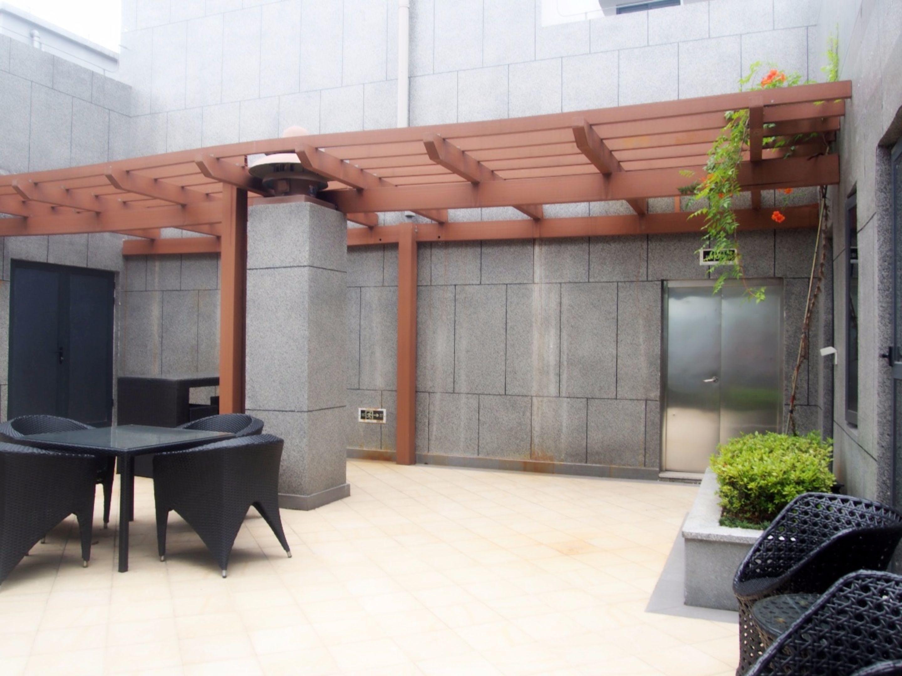 An outdoor seating area with a pergola, a table, and chairs.