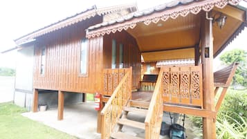 A wooden house with a porch, steps, and a fire extinguisher.