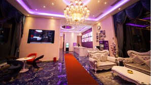 A modern hotel lobby with a chandelier, seating area, and a bar. - Brightman Theme Hotel (Foshan)