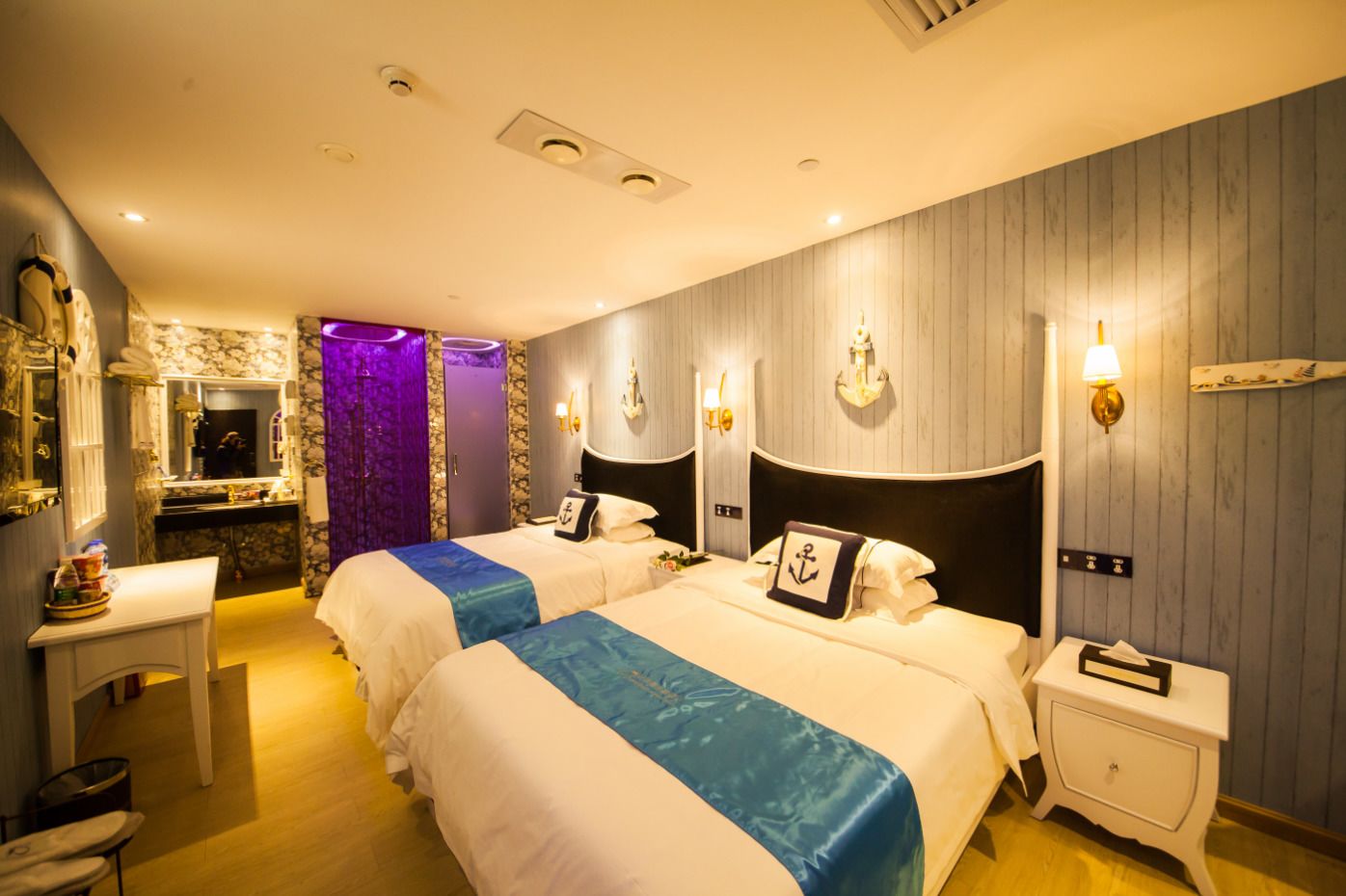 Een hotelkamer met twee bedden, een kaptafel met spiegel, en een badkamer met douche.