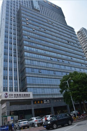 A tall, modern building with a glass facade and multiple floors. - Brightman Theme Hotel (Foshan)