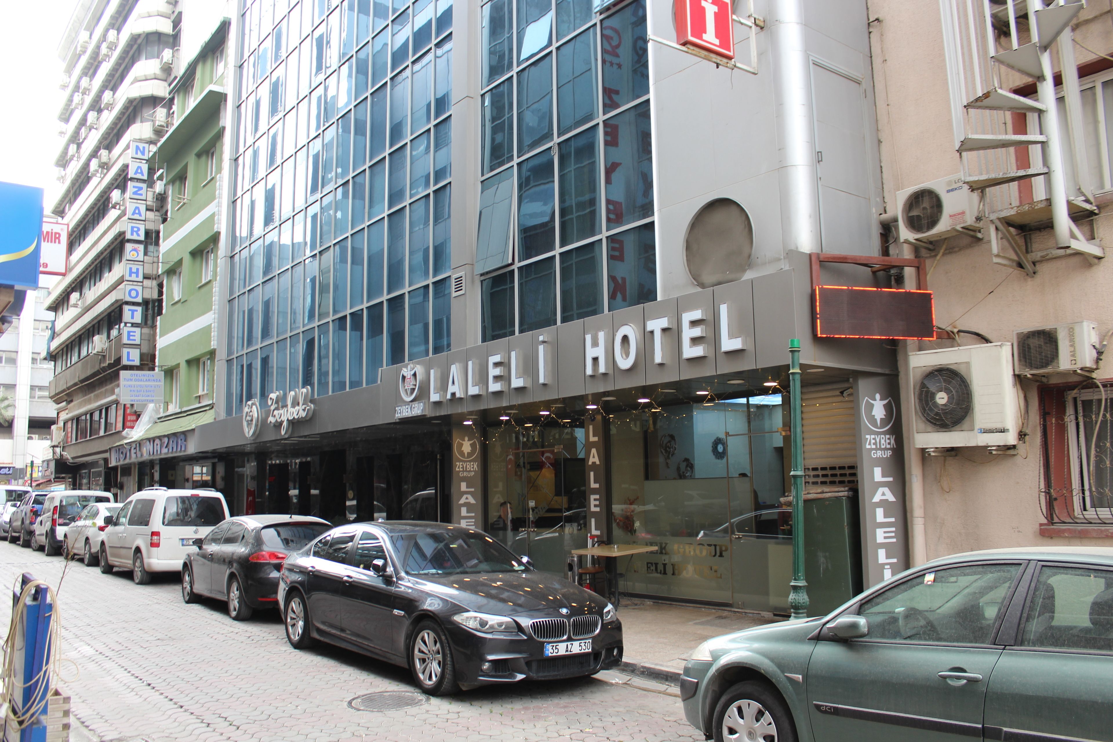 Un hotel con fachada moderna, varios pisos y un letrero llamativo.