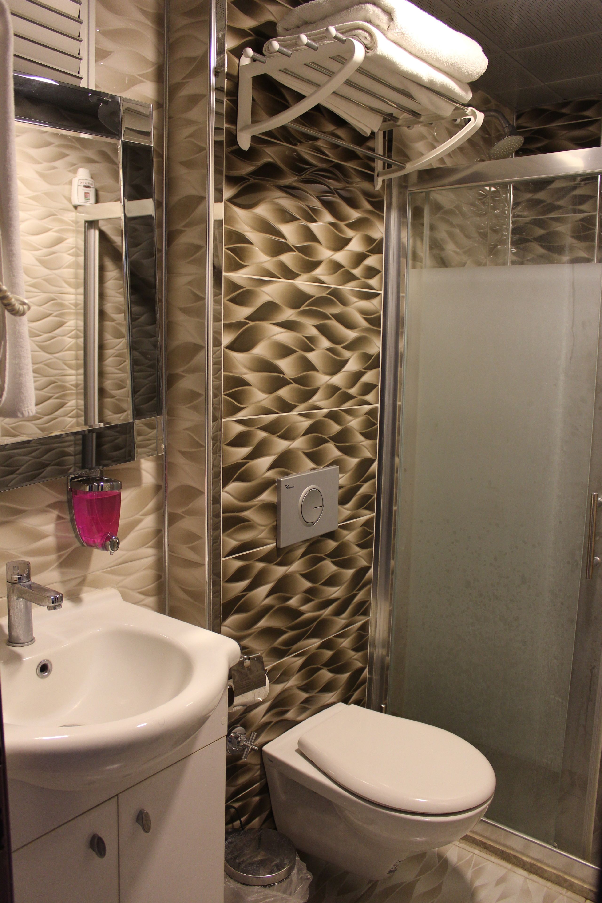 A bathroom with a sink, toilet, and a glass shower enclosure.