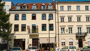 Un immeuble doté de nombreuses fenêtres et d’un balcon.