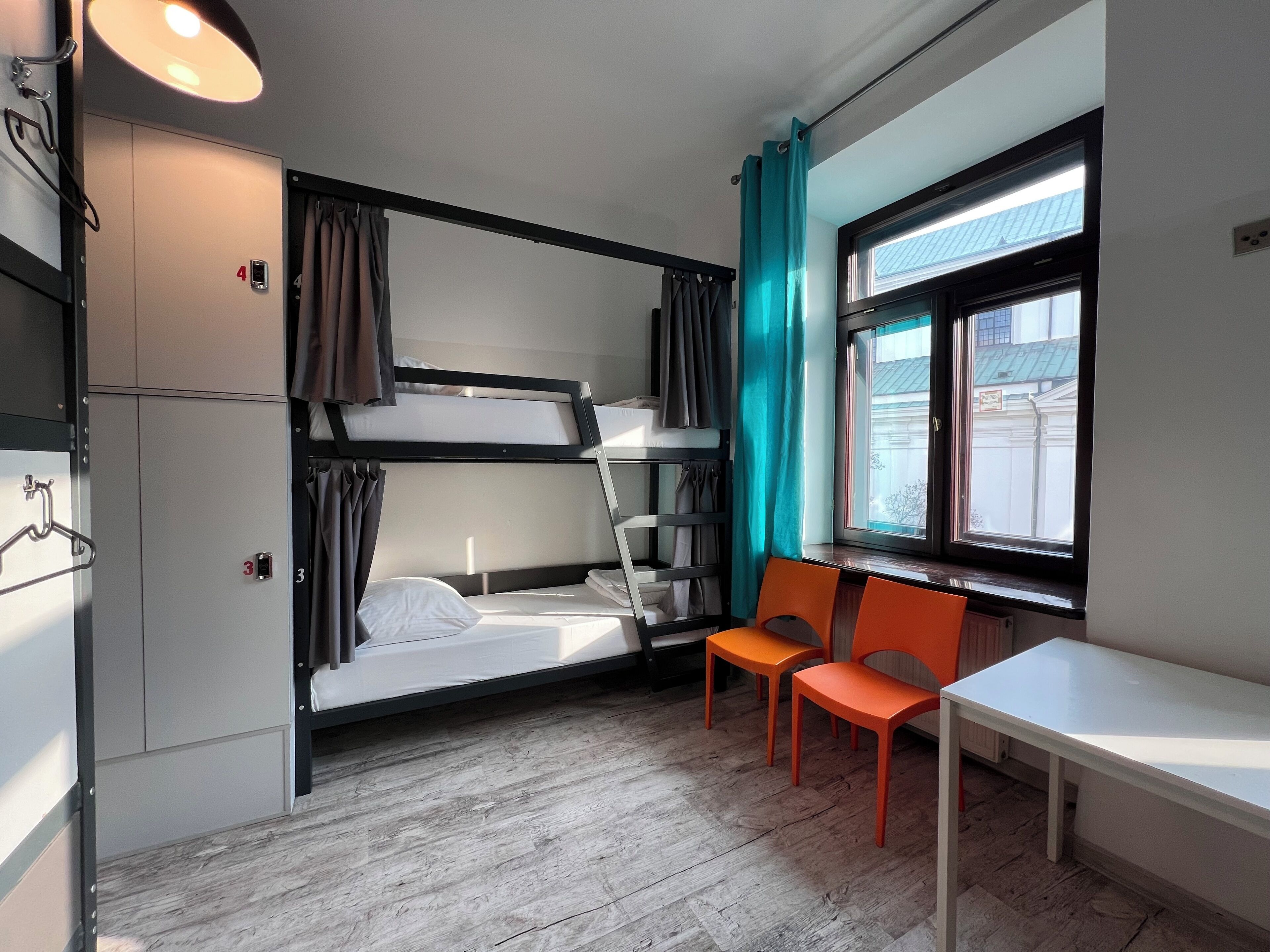 A compact room with bunk beds, a small table, and chairs.