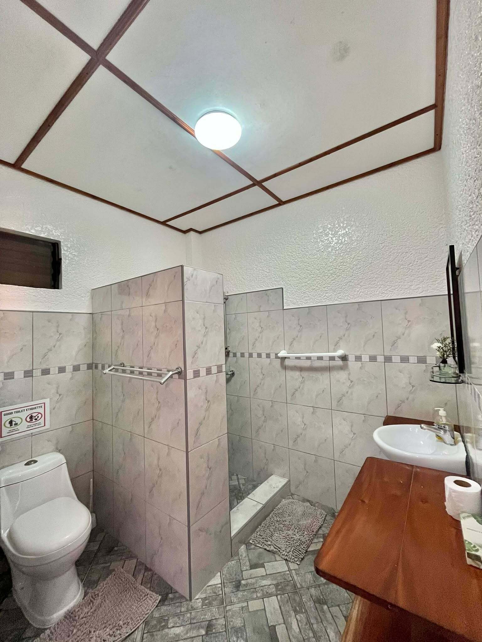 A bathroom with a toilet, sink, and shower.